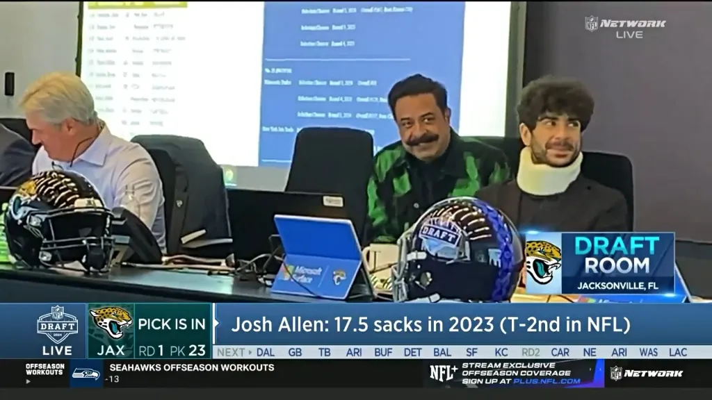 Tony Khan shown wearing a neck brace during NFL Draft